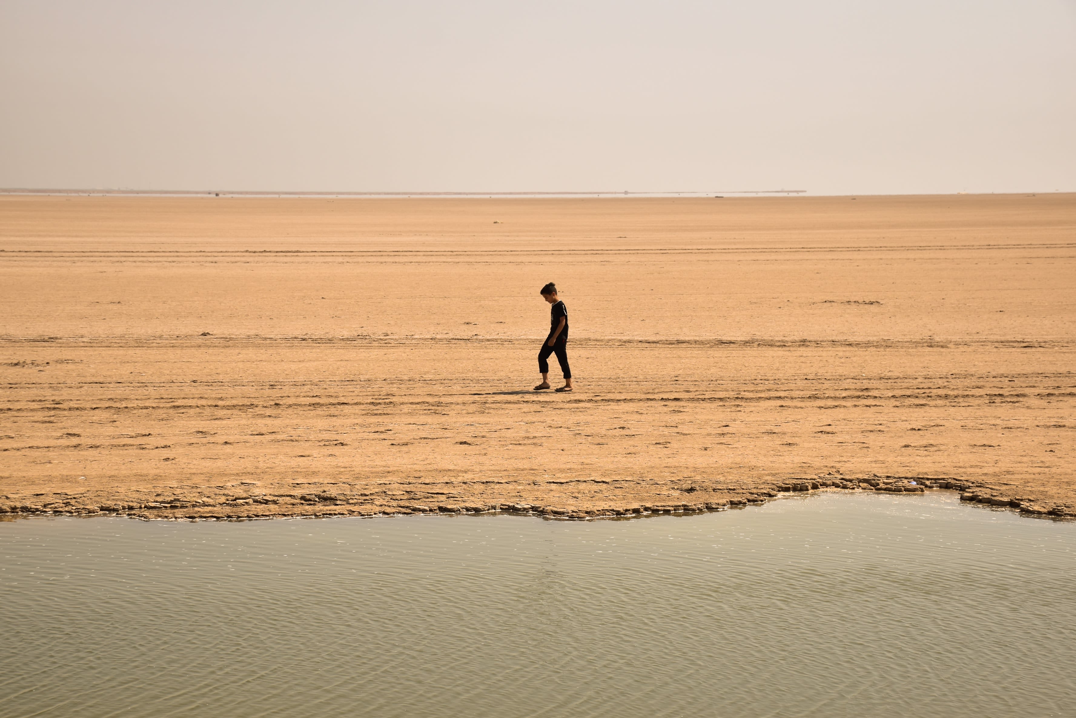 man walking on brown sand during daytime